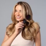 Woman holding a hair brush, illustrating hair growth products for women