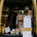 Mover loading cardboard boxes into a van, illustrating a moving service review