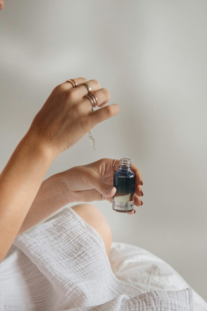 Hand holding a black glass serum bottle, illustrating a skincare serum review