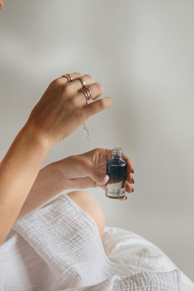 Hand holding a black glass serum bottle, illustrating a skincare serum review